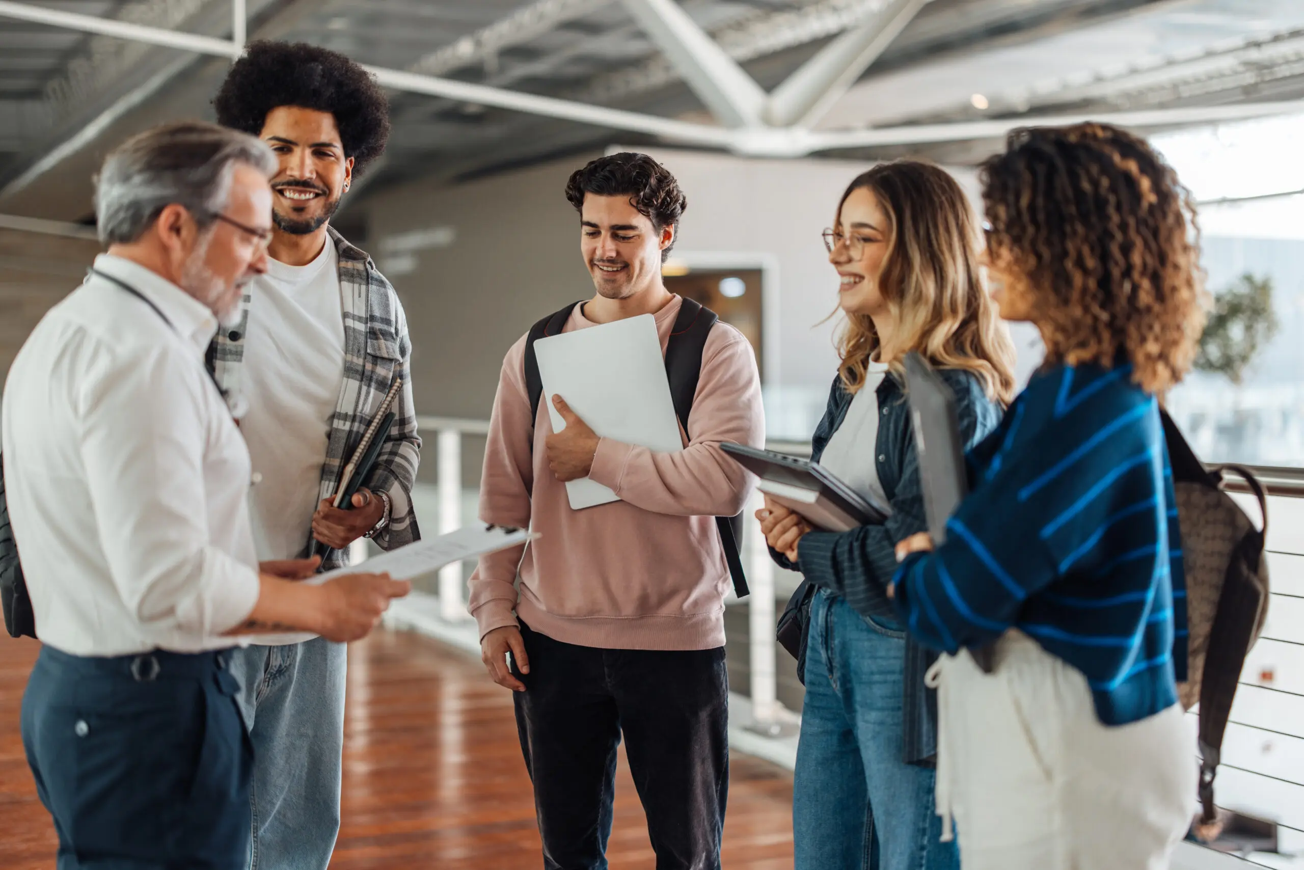 Young adults in conversation, holding papers