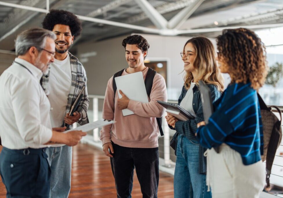 Young adults in conversation, holding papers